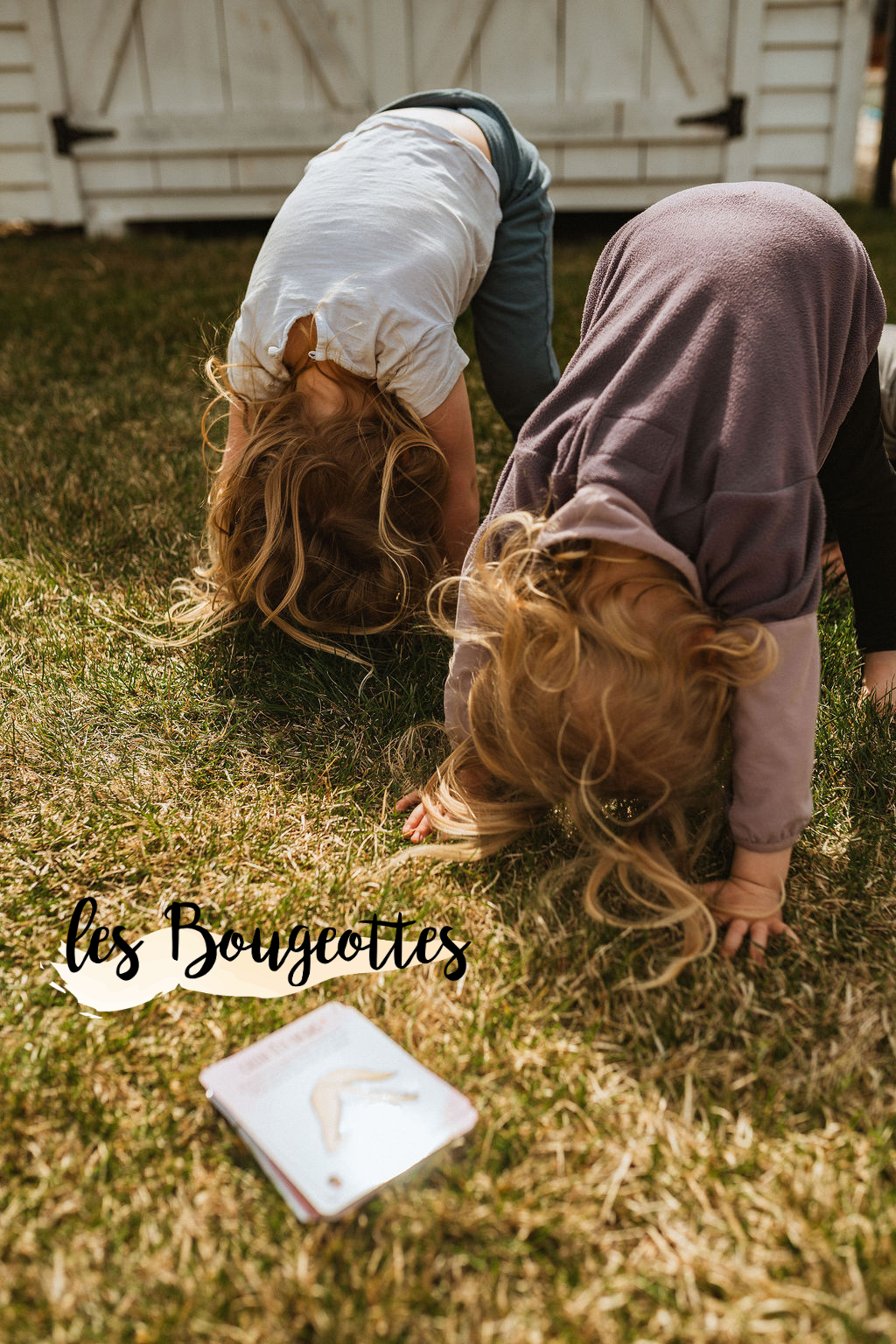 Deux enfants qui font du yoga dans l'herbe